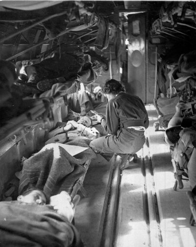 Miss Mary Smith of South Carolina treating patients during flight to North Africa, c.1943-45, from a collection of 650 photographs compiled by the Commando Association by American Photographer